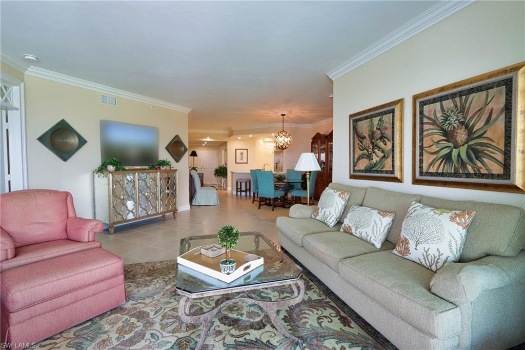 60 Seagate Drive, Unit 402 Naples, FL 34103 - Photo 5 of 26 a living room with furniture and a flat screen tv