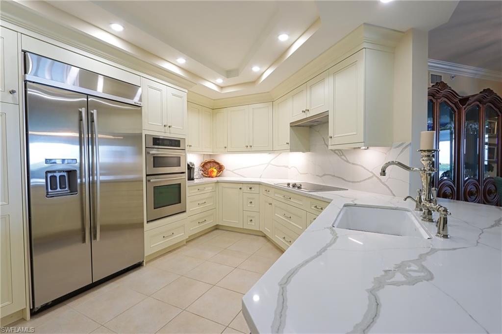 60 Seagate Drive, Unit 402 Naples, FL 34103 - Photo 8 of 26 a kitchen with stainless steel appliances granite countertop a refrigerator and a sink