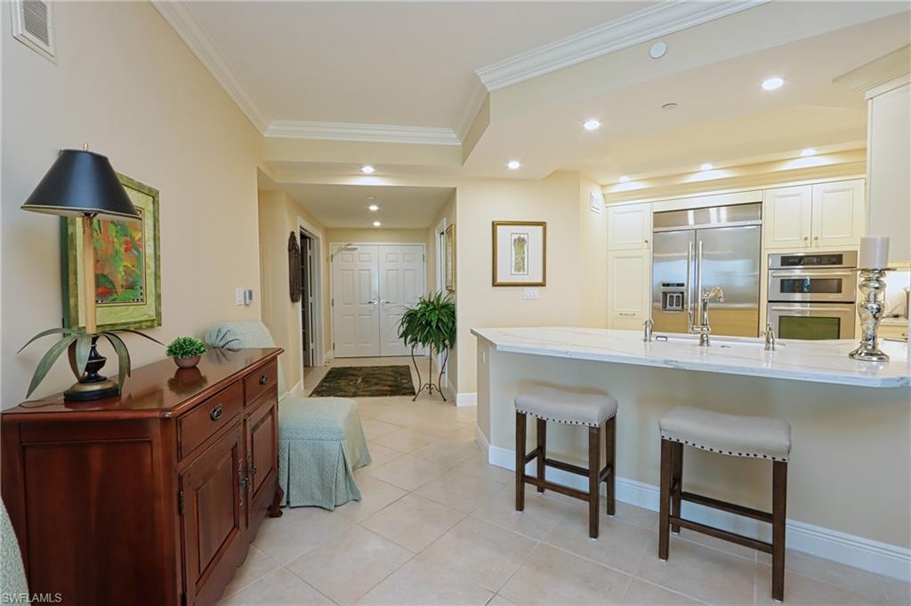 60 Seagate Drive, Unit 402 Naples, FL 34103 - Photo 10 of 26 a living room with furniture and a wooden floor