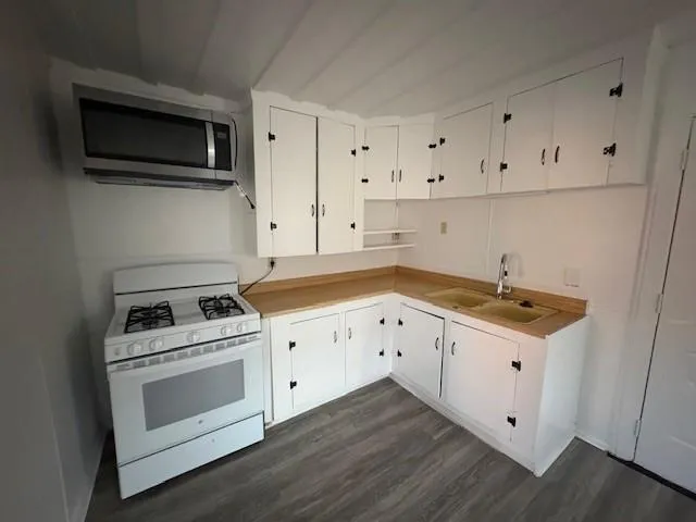 a kitchen with cabinets stove and sink
