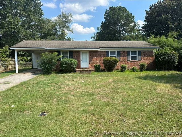 a view of a house with a yard and sitting area