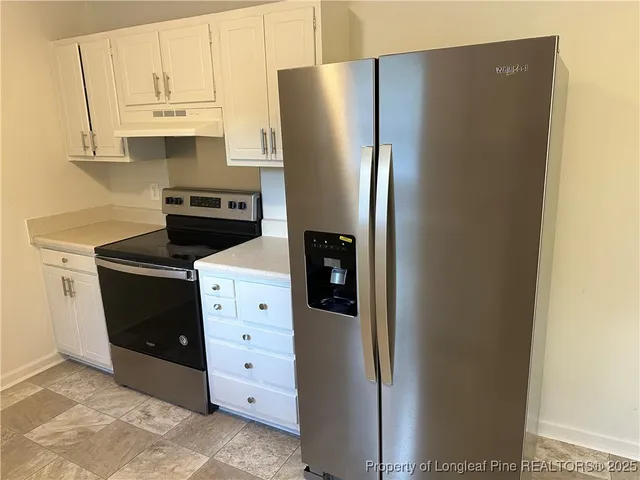 a kitchen with cabinets and a refrigerator