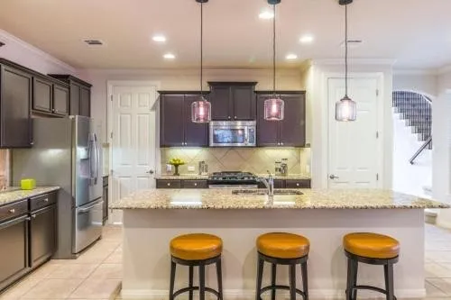 a kitchen with stainless steel appliances granite countertop a sink a refrigerator and a stove