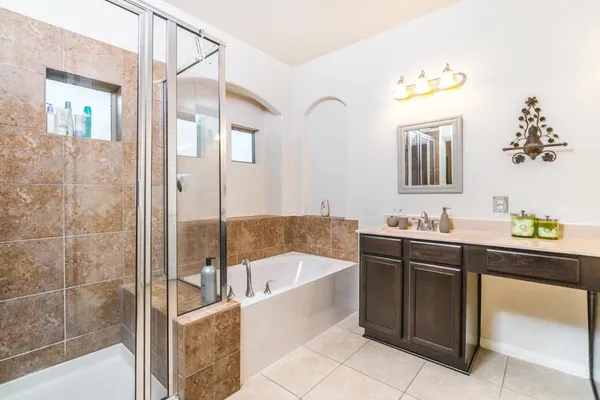 a bathroom with a tub sink and mirror