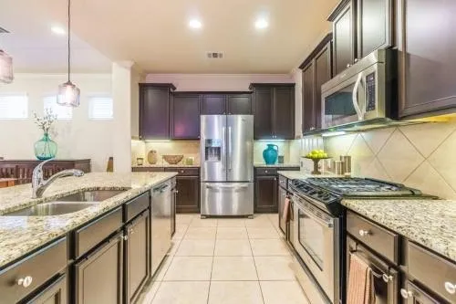 a kitchen with stainless steel appliances granite countertop a sink stove and refrigerator