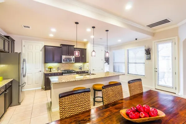 a kitchen with a refrigerator a stove a sink dishwasher and wooden cabinets with wooden floor