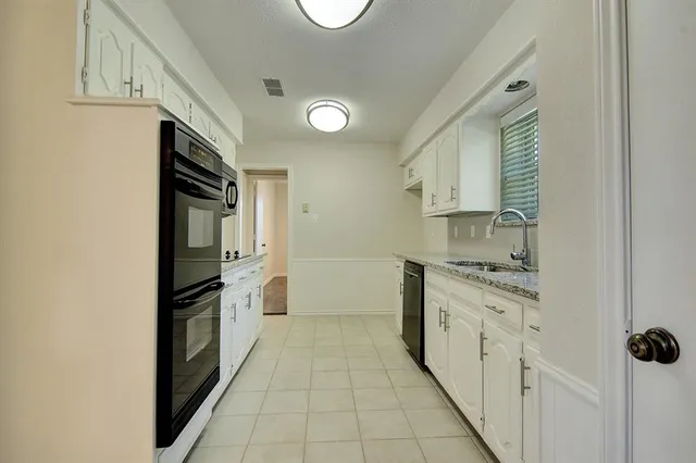 a kitchen with granite countertop a refrigerator and a stove