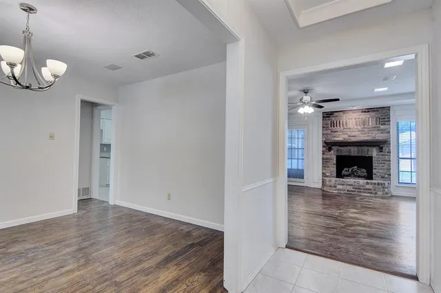 a view of an empty room with wooden floor and a fireplace