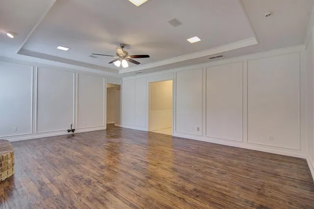 wooden floor in an empty room with a ceiling fan