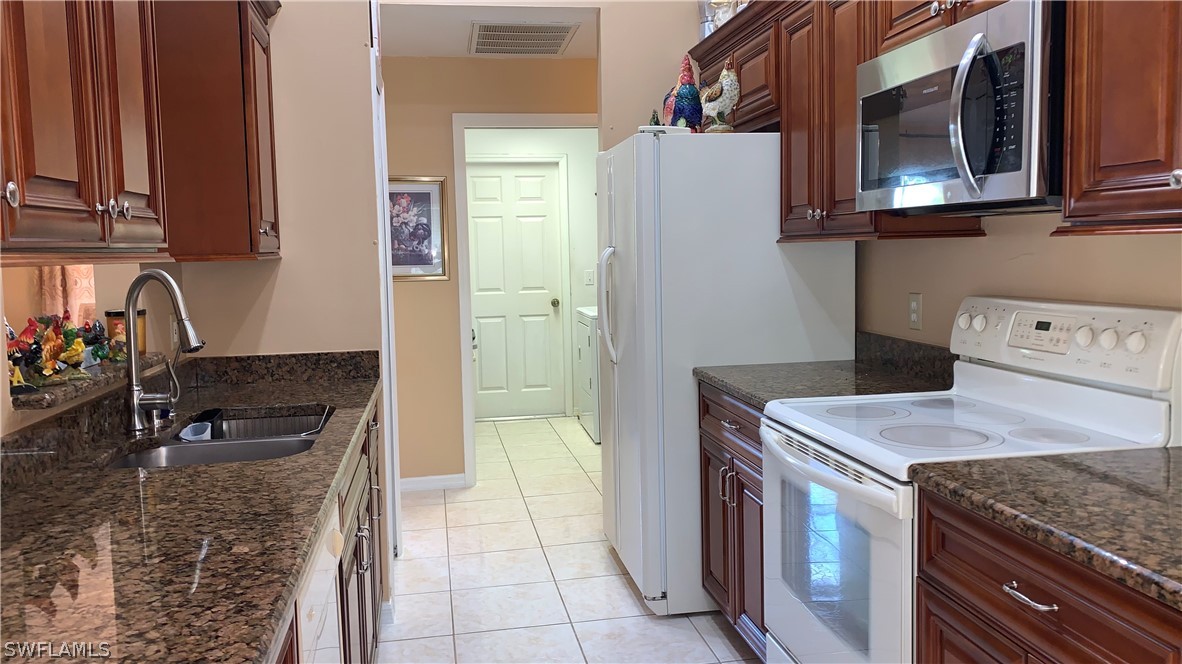 9116 Irving Road Fort Myers, FL 33967 - Photo 12 of 21 a kitchen with stainless steel appliances granite countertop a stove and a microwave