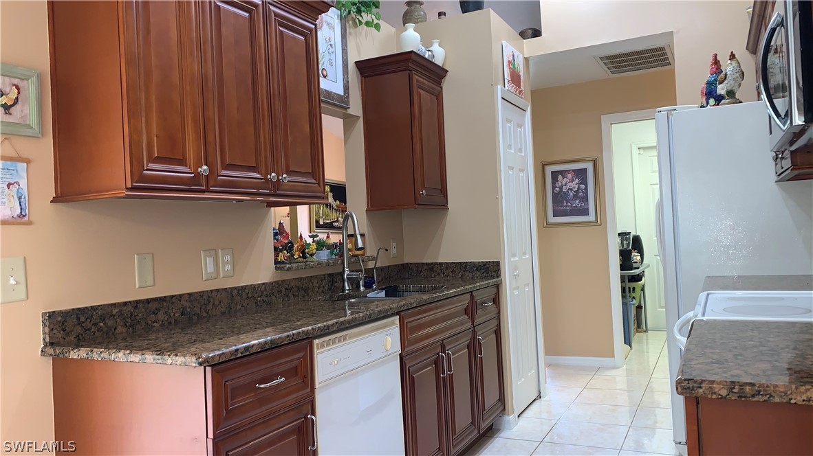 9116 Irving Road Fort Myers, FL 33967 - Photo 13 of 21 a kitchen with granite countertop a sink and a refrigerator