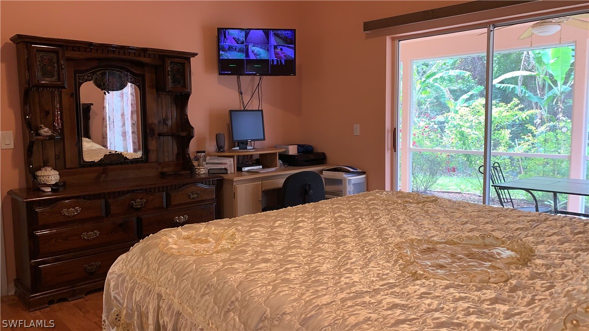 9116 Irving Road Fort Myers, FL 33967 - Photo 3 of 21 a bedroom with a bed and a flat tv screen on dresser