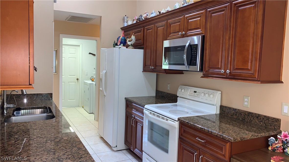 9116 Irving Road Fort Myers, FL 33967 - Photo 10 of 21 a kitchen with a stove microwave and refrigerator