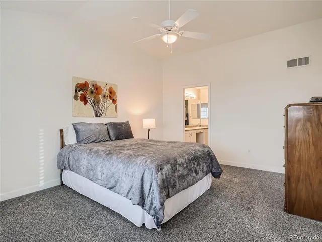 a spacious bedroom with a bed and a chandelier