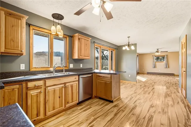 a large kitchen with stainless steel appliances granite countertop a stove a sink dishwasher and a refrigerator with wooden floor