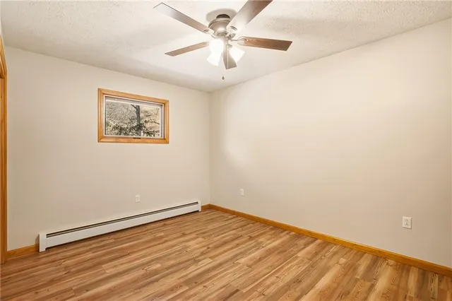 an empty room with a fan and a window