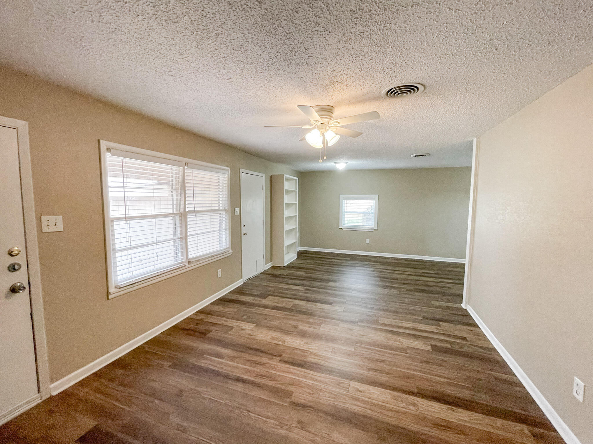 5424 23rd Street Lubbock, TX 79407 - Photo 2 of 11 a view of an empty room with a window and wooden floor