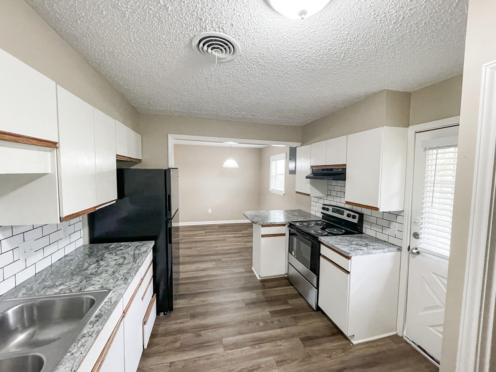 5424 23rd Street Lubbock, TX 79407 - Photo 4 of 11 a kitchen with stainless steel appliances granite countertop a stove top oven a sink a refrigerator and white cabinets