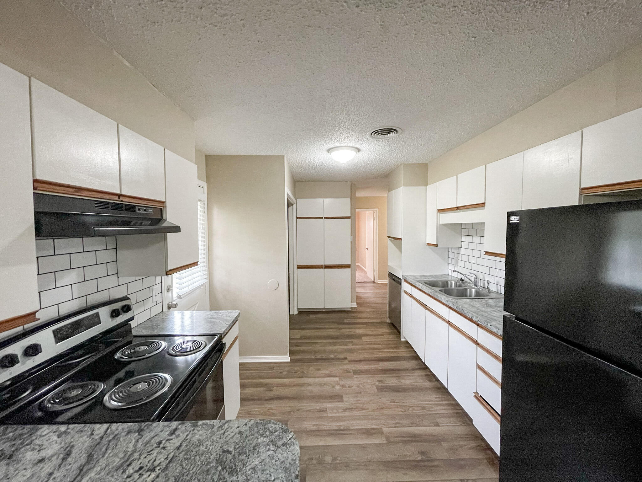 5424 23rd Street Lubbock, TX 79407 - Photo 5 of 11 a kitchen with stainless steel appliances kitchen island granite countertop a stove and a refrigerator