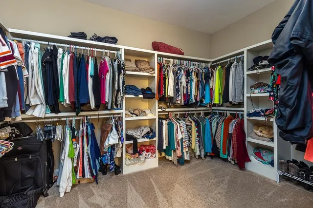 a view of walk in closet with clothes
