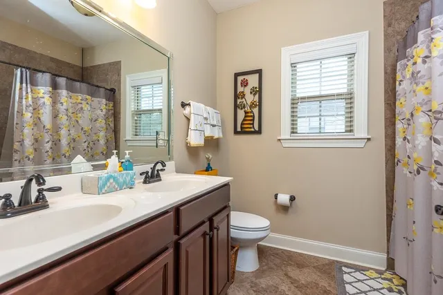 a bathroom with a sink a toilet and a window