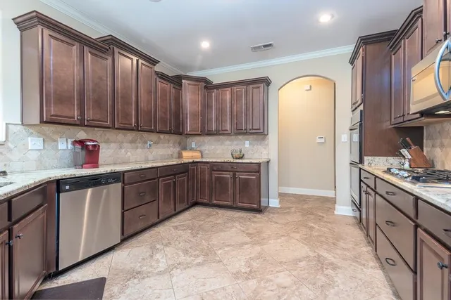 a kitchen with granite countertop a stove top oven sink and cabinets