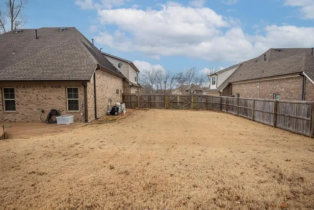 a backyard of a house with a large tree
