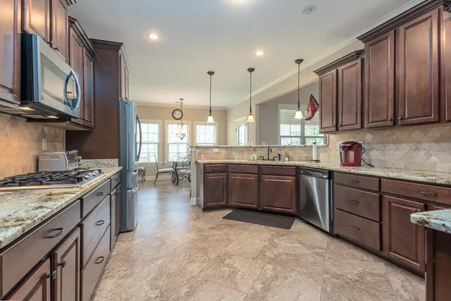 a kitchen with a stove sink cabinets and a refrigerator