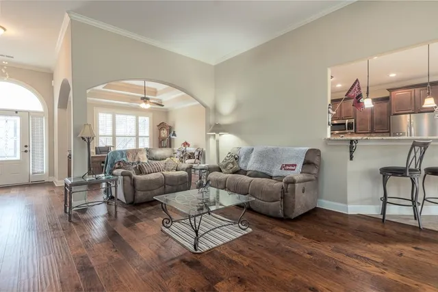 a living room with furniture and a large mirror with wooden floor