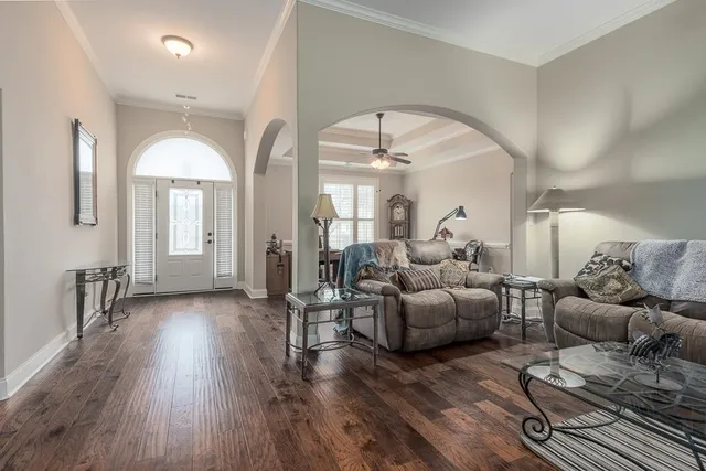 a living room with couches and a mirror with wooden floor