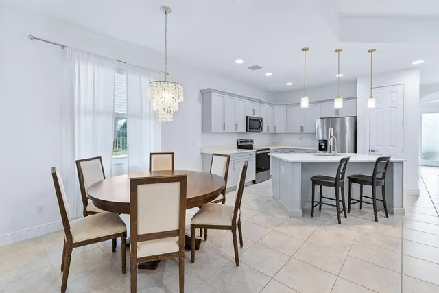 a view of a dining room and livingroom with furniture a chandelier