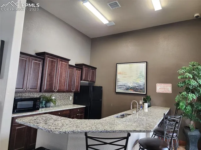 a kitchen with a table chairs and refrigerator