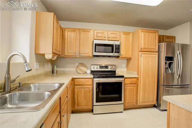 a kitchen with stainless steel appliances granite countertop a refrigerator stove and sink