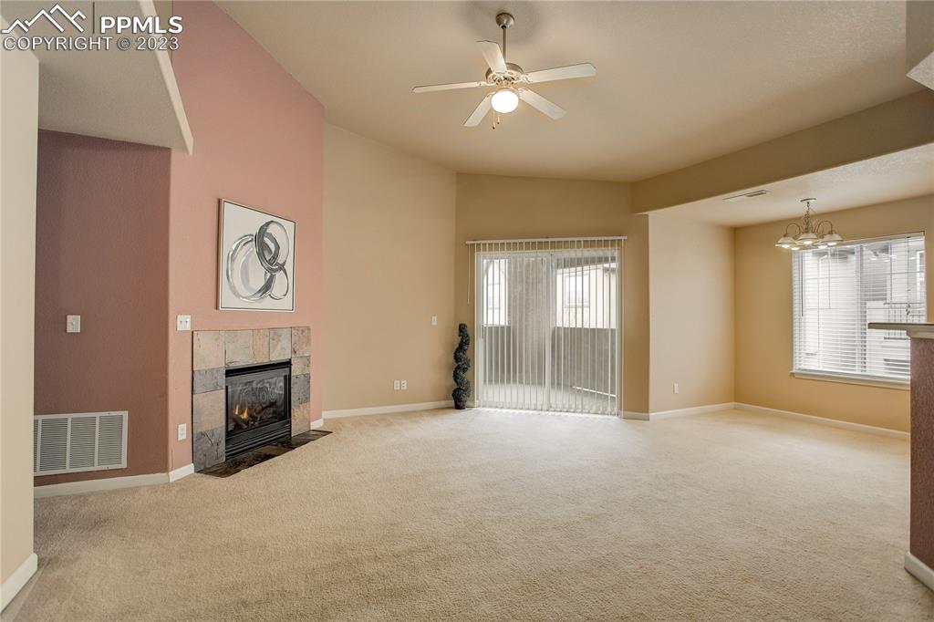 7005 Prairie Finch Heights, Unit 203 Colorado Springs, CO 80922 - Photo 7 of 39 a view of a livingroom with a fireplace a chandelier fan and windows