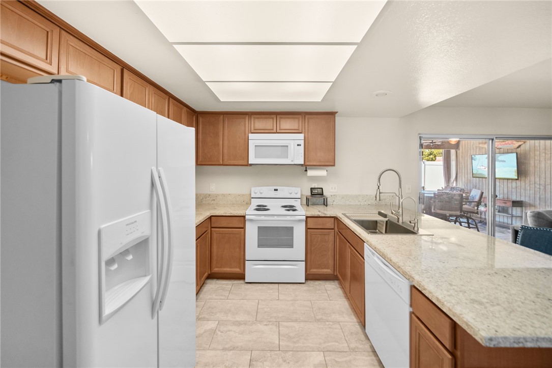 27879 Foxfire Street Menifee, CA 92586 - Photo 14 of 36 a kitchen with stainless steel appliances granite countertop a sink stove and refrigerator