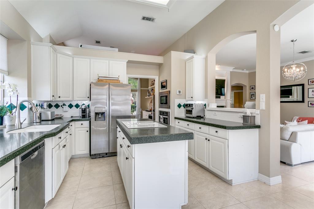 1509 Blue Mesa Road Carrollton, TX 75007 - Photo 12 of 35 a kitchen with stainless steel appliances granite countertop a sink stove and refrigerator