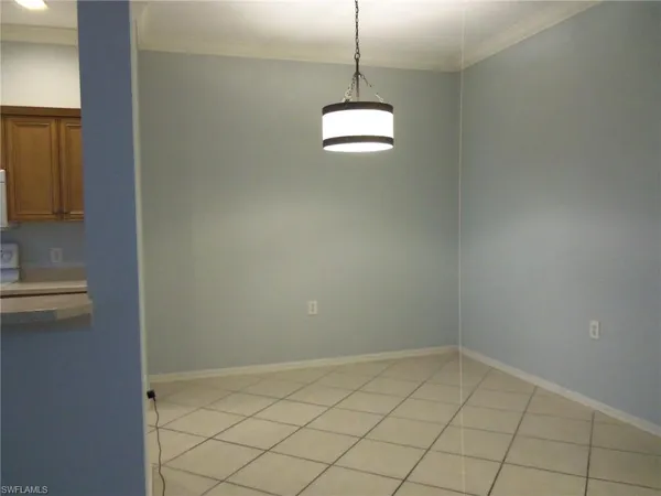 a view of a room with a hanging light and kitchen