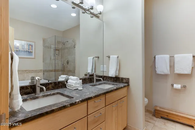 a bathroom with a sink vanity mirror and toilet
