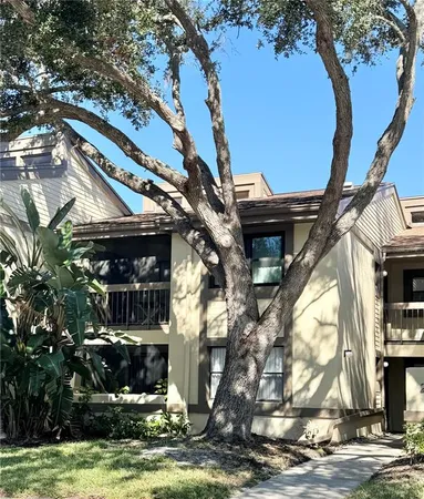 a view of a house with a tree next to a yard