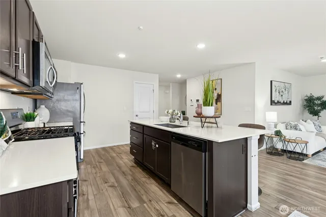 a kitchen with stainless steel appliances granite countertop a sink stove and wooden floor
