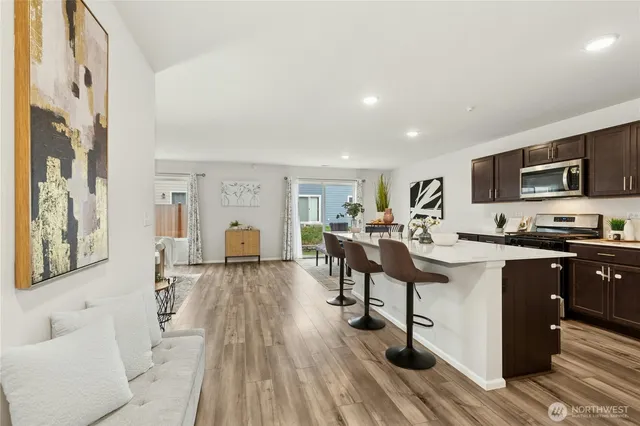 a living room with furniture appliances and wooden floor