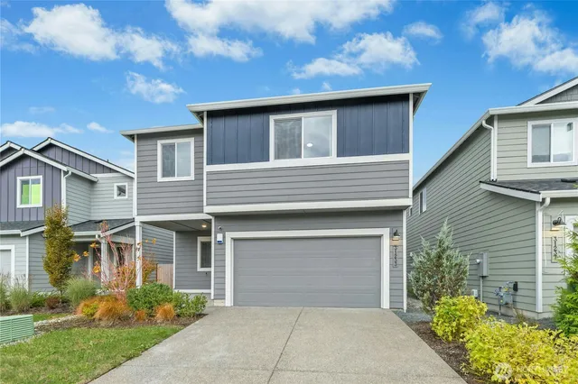 a front view of house with yard and trees around