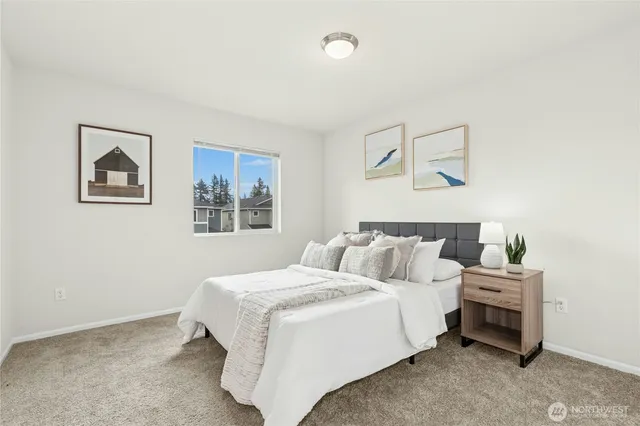 a bedroom with a bed and painting on the wall