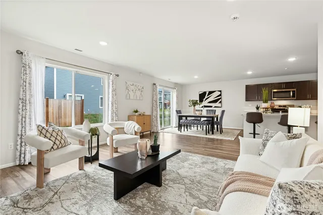 a living room with furniture and a view of kitchen