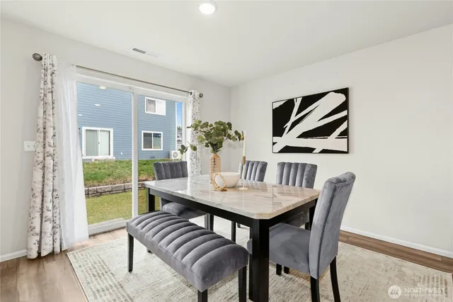 a view of a dining room with furniture wooden floor and next to a window