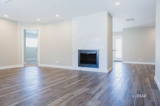 513 Suzanne Street Ridgecrest, CA 93555 - Photo 8 of 34 a view of empty room with wooden floor and fireplace