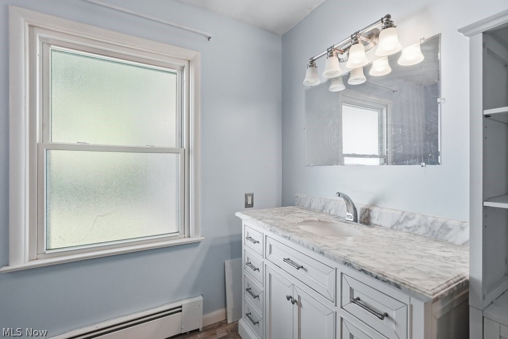 136 Pinehurst Road Munroe Falls, OH 44262 - Photo 19 of 48 Bathroom vanity featuring a light marble-finish countertop with an undermount sink, brushed nickel faucet, and white cabinetry with brushed nickel hardware