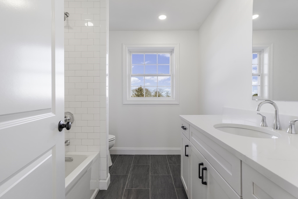 62 High Street, Unit LOT 7 Stoneham, MA 02180 - Photo 14 of 19 a bathroom with a tub sink toilet and a mirror