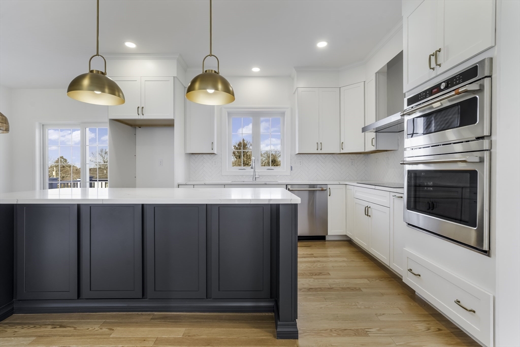62 High Street, Unit LOT 7 Stoneham, MA 02180 - Photo 4 of 19 a kitchen with a sink stainless steel appliances and cabinets