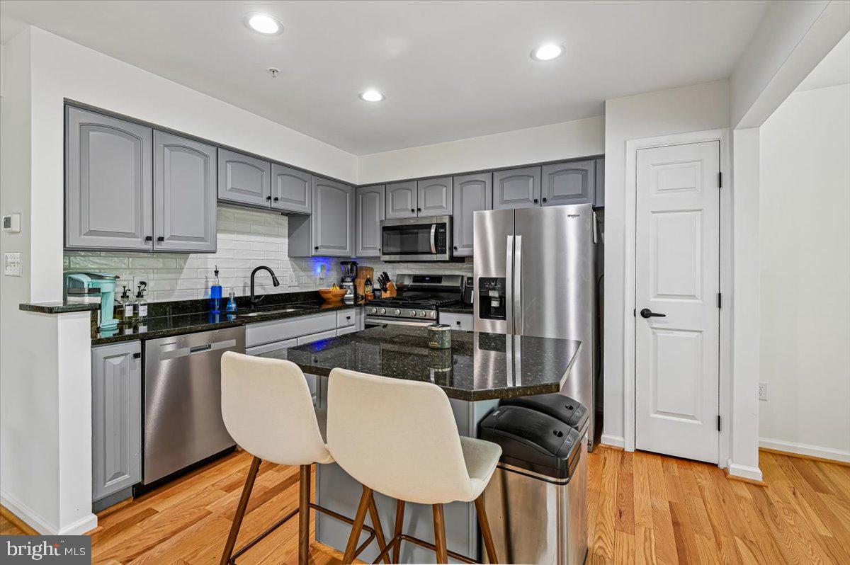 2401 High Brandy Way Odenton, MD 21113 - Photo 10 of 61 a kitchen with stainless steel appliances granite countertop a refrigerator a stove a sink dishwasher and white cabinets with wooden floor
